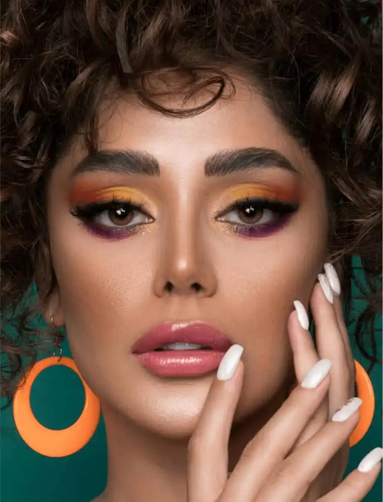 Close-up of woman with vibrant eye makeup, defined brows, and long lash extensions, showcasing the beauty services at Lalalash's salon.